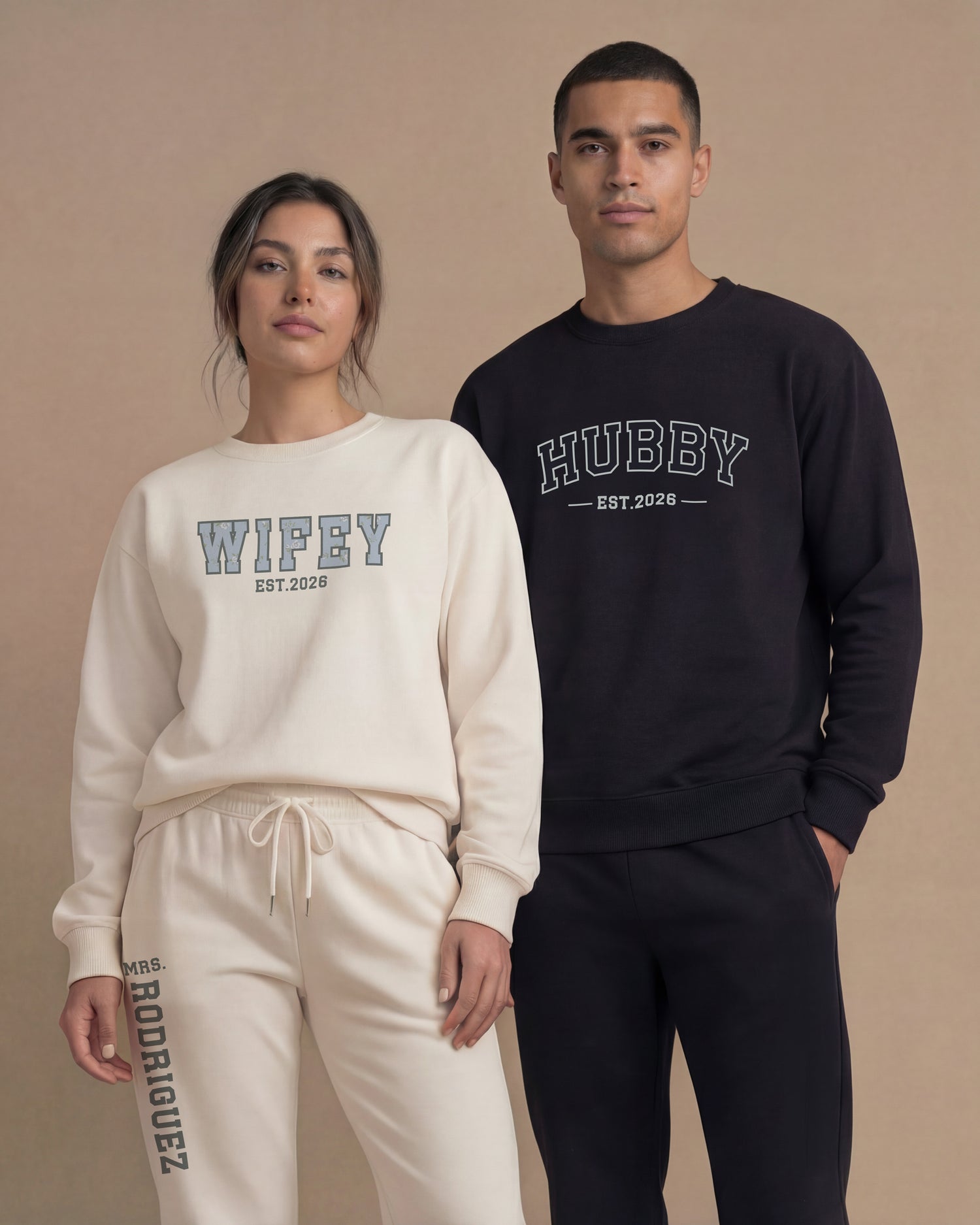 Couple wearing matching sweatshirt sets with 'WIFEY' and 'HUBBY' print in trendy varsity font
