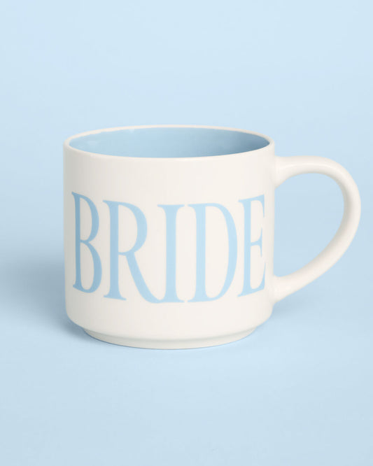 An off-white ceramic mug with a light blue interior and handle, featuring the word 'BRIDE' printed in light blue serif letters on the front, set against a solid light blue background.