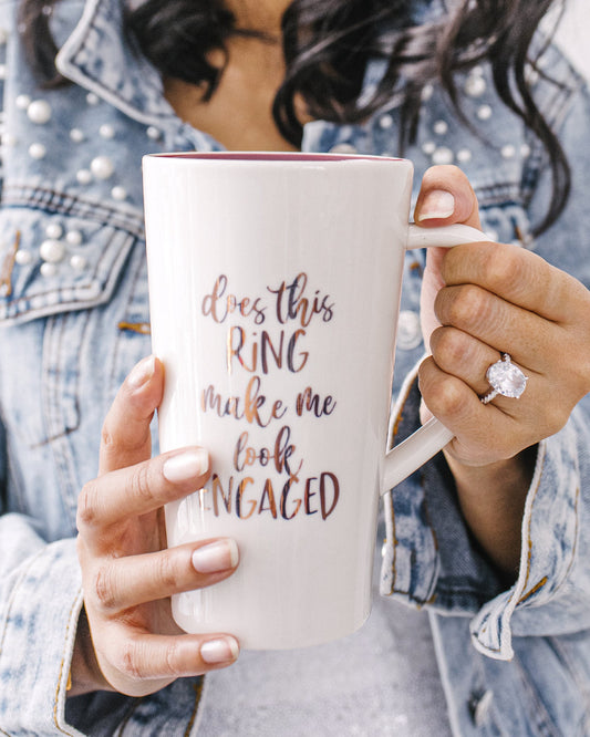 Cute ceramic mug that reads "Does This Ring Make Me Look Engaged?".