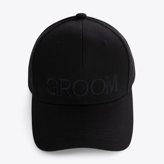 A black baseball cap with the word 'GROOM' embroidered in tonal black lettering across the front, shown against a plain light gray background.