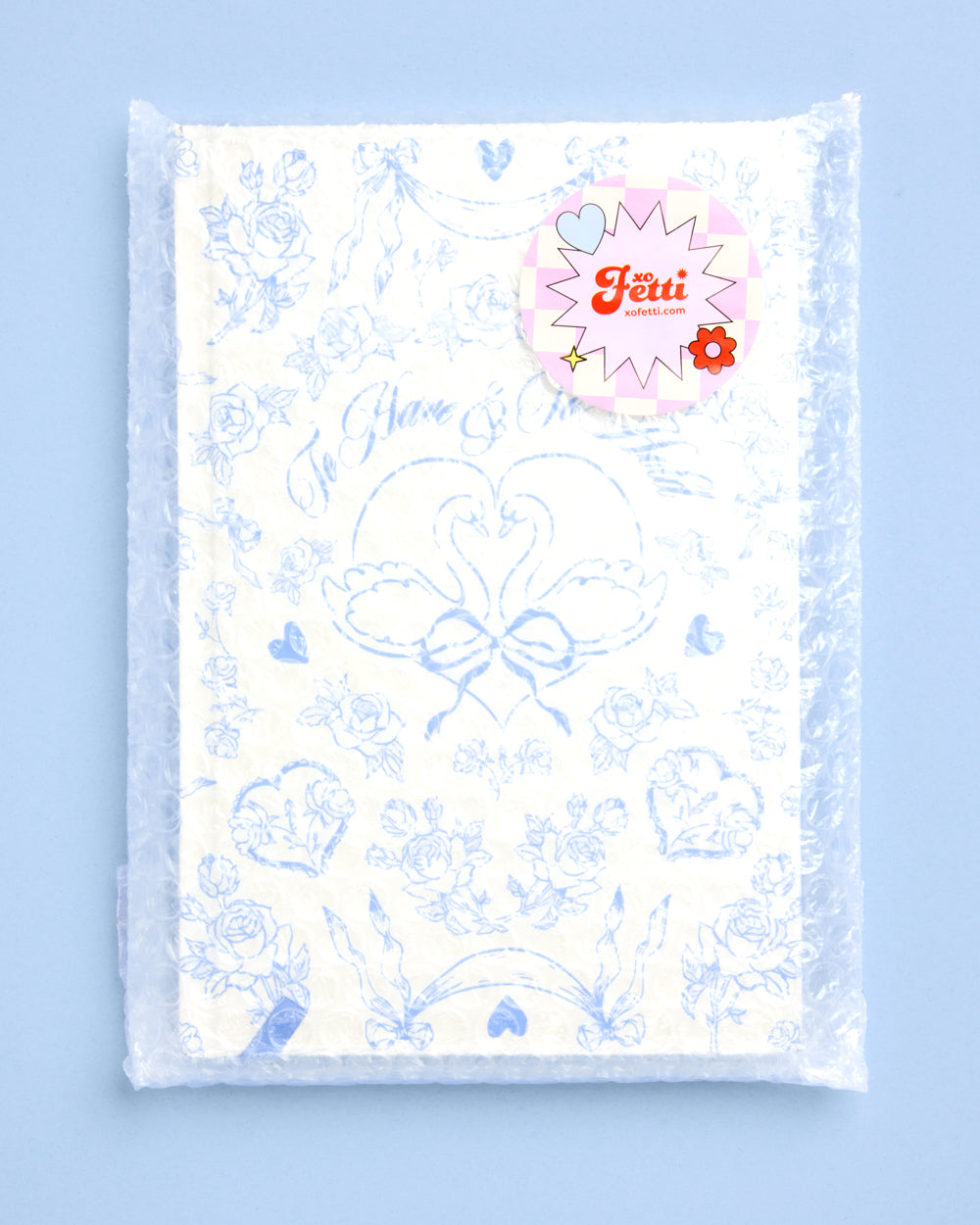 Packaged product with floral design and a visible brand logo on a light blue background