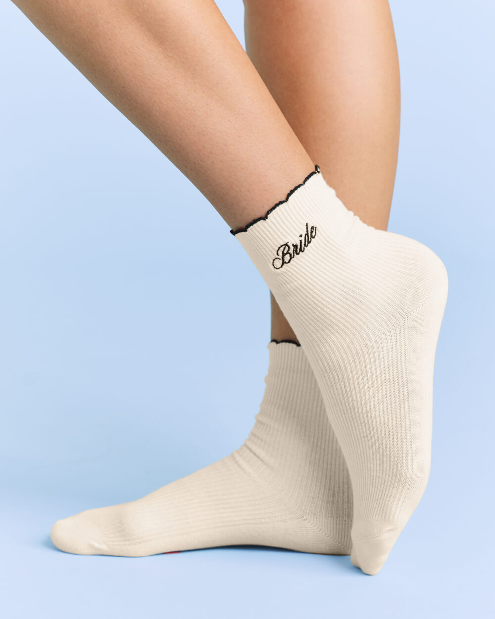 Beige socks with 'Bride' text on a light blue background