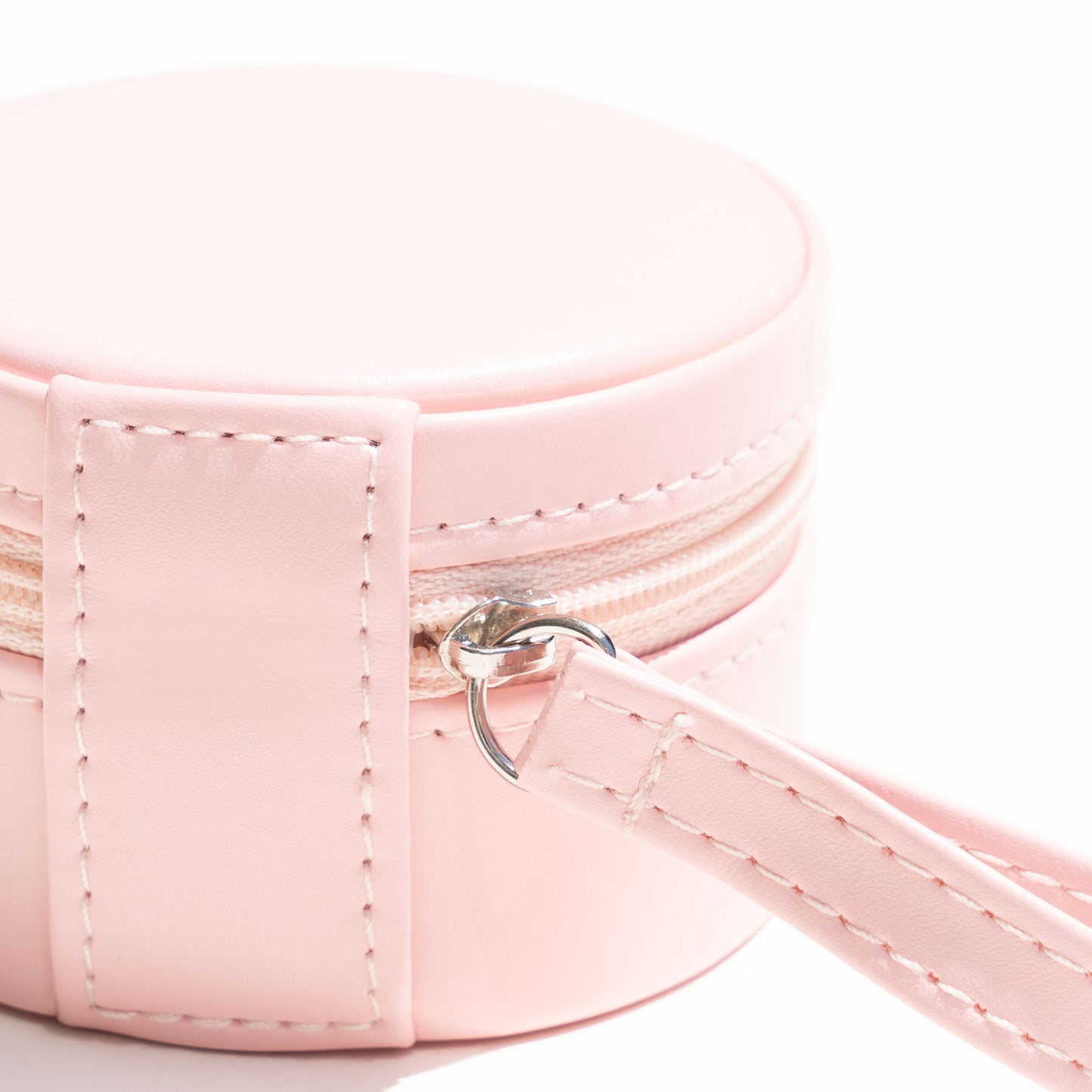 Pink Vegan Leather Travel Jewelry Box with a small wristlet for easy holding.